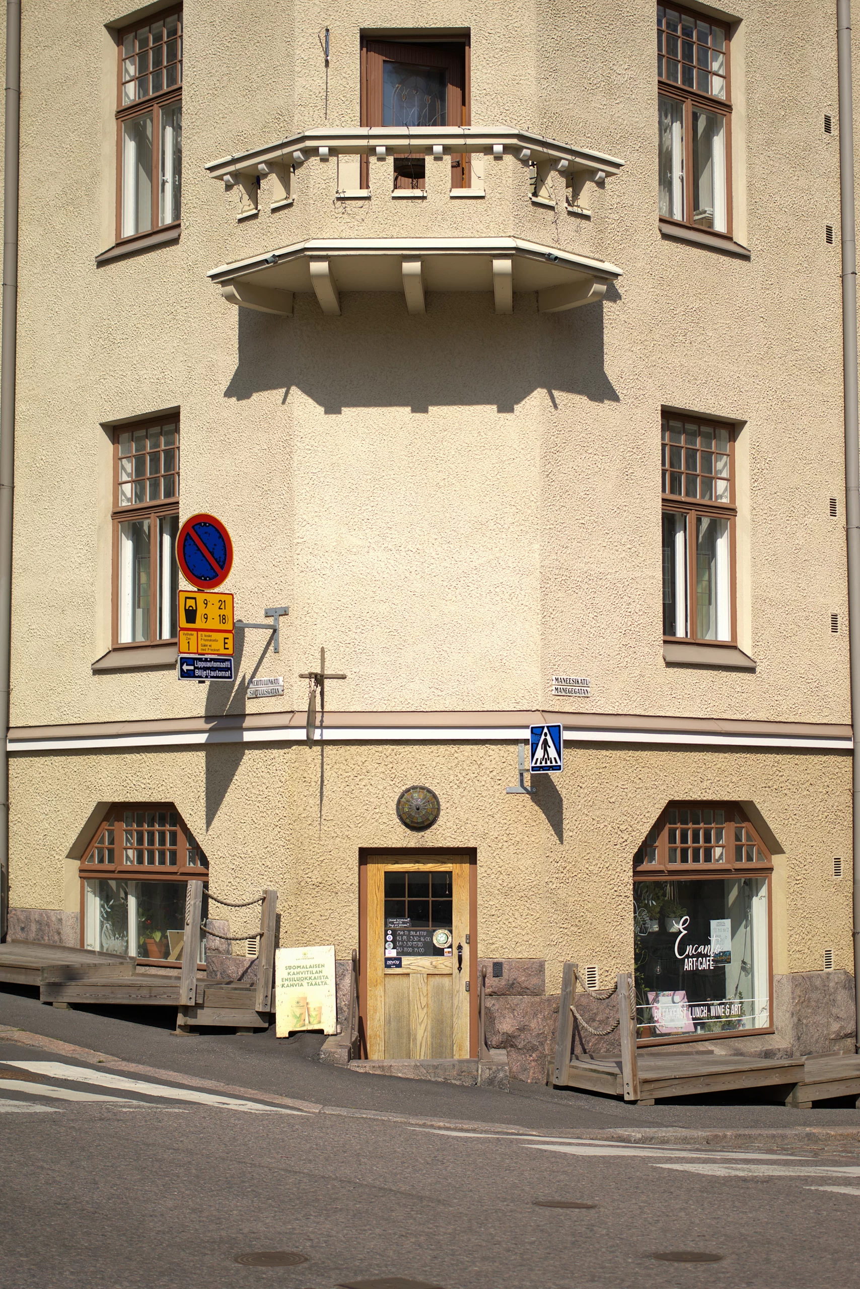 Katunäkymä Encanto Art Cafesta, keskellä esteellinen sisäänkäynti ja molemmilla puolilla isot ikkunat